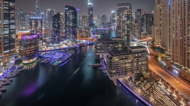 Havadan Dubai marina gökdelenleri ve kanalın etrafındaki JBR kuleleri ve gece gündüz yüzen botlarla geçiş zamanı. Günbatımından sonra beyaz tekneler yat kulübüne park edilir.