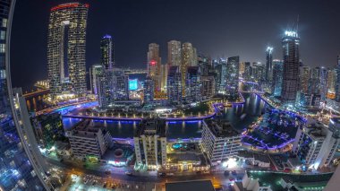 Dubai Marina 'nın panoramik manzarası. Limanda birkaç tekne ve yatlar var. Kanal anteninin etrafındaki gökdelenler. Arka planda JBR bölgesi kuleleri