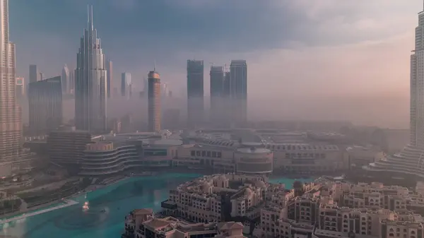 空中的晨雾覆盖了迪拜国际金融中心区的时间 日出时带现代摩天大楼和购物中心的写字楼和酒店 — 图库照片