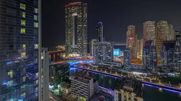 Panorama, Dubai Marina 'yı limana park etmiş birkaç tekne ve yatla gösteriyor. Kanal havası çevresindeki gökdelenleri aydınlatıyor. Arka planda JBR bölgesi kuleleri