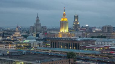 Moskova, Rusya 'daki Komsomolskaya meydanındaki üç tren istasyonunun gece gündüz geçiş zamanlarının en iyi görüntüsü. Trenler raylarda. Arka planda Stalin gökdelenleri var. Çatıdan hava görüntüsü