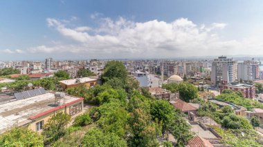 Panorama, Arnavutluk 'un Durres limanı ve şehir merkezinin (eski kent) hava manzarasını gösteriyor. Gökyüzünde bulutlar olan, kırmızı çatıları ve yeşil ağaçları olan birçok ev.