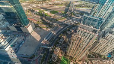 Gökdelenler arasındaki yol kesişiminin havadan görünüşü tüm gün boyunca gölgelerin hızlı hareket ettiği bir zaman dilimi boyunca düşüktür. BAE 'nin Dubai Marina bölgesinin şehir manzarası. Arabaları ve tramvayı var.