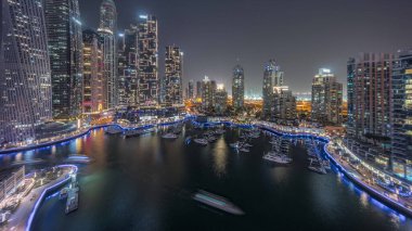 Dubai marinası en uzun gökdelenler ve yatlar liman havasından geceye gün batımından sonra geçiş. Apartman binalarına, otellere ve ofis bloklarına, BAE 'nin modern yerleşim alanlarına bak