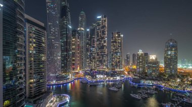 Dubai marinası en uzun gökdelenler ve yatlar liman havası gece panoramiklerinde gün batımından sonra. Apartman binalarına, otellere ve ofis bloklarına, BAE 'nin modern yerleşim alanlarına bak