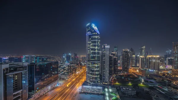 Panorama showing Dubai Downtown and business bay night timelapse with tallest skyscraper and other illuminated towers view from the top in Dubai, United Arab Emirates.