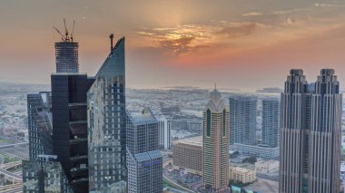 Dubai 'deki Sheikh Zayed Yolu' ndaki yüksek binalar. Gün batımında uluslararası finans bölgesinde gökdelenler. Arka planda evler ve villalar var.