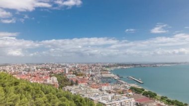 Panorama, Portekiz 'in Setubal şehrinde marina ve şehir merkezinin hava görüntülerini gösteriyor. Kırmızı çatılar ve kıyı şeridi yukarıdan gelen tekne ve gemilerle. Güneşli bir günde bulutlu bir gökyüzü
