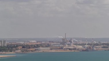 Dumanı tüten hava zaman ayarlı Setubal Termoelektrik Santrali. Portekiz 'in Setubal kenti yakınlarında bulunan ve akaryakıt kullanılan devre dışı bırakılmış elektrik santrali. Sanayi fabrikası