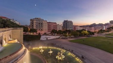 Panorama Alameda Dom Afonso Henriques 'in çimlerini renkli binalar ve aydınlatılmış Aydınlık Çeşme havadan geceye geçiş süresini gösteriyor Lizbon, Portekiz' de gün batımından sonra yukarıdan