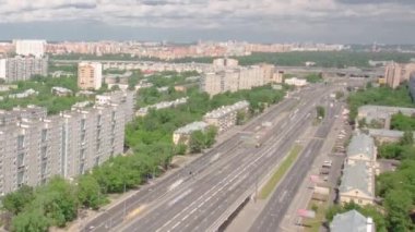 Rusya 'nın başkenti Moskova' daki Yaroslavl otobanındaki yüksek caddedeki hava yolu zaman tüneli üst geçidinde trafiğin en üst görüntüsü. Bir sürü evi ve yeşil ağaçları olan bir panorama.