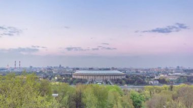 Moskova City, Rusya 'nın panoramik manzarası, gün batımından sonra Sparrow Hills' ten gece geçiş zamanına kadar. Luzhniki Stadyumu ve nehir üzerindeki köprü