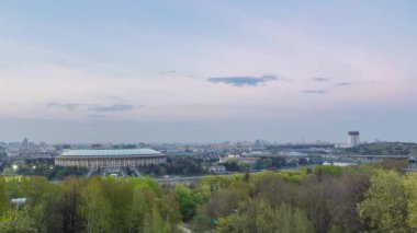 Moskova City, Rusya 'nın panoramik manzarası, gün batımından sonra Sparrow Hills' ten gece geçiş zamanına kadar. Luzhniki Stadyumu ve nehir üzerindeki köprü