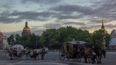 St. Petersburg 'da Sunset Timelapse' de Palace Meydanı 'nda romantik at arabaları. Amirallik Binası ve St. Isaacs Katedrali Arkaplan Grace
