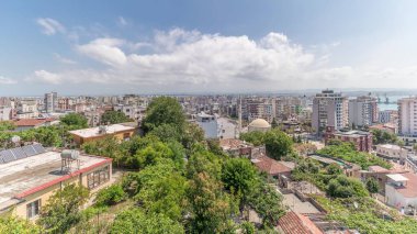 Panorama, Arnavutluk 'un Durres limanı ve şehir merkezinin (eski kent) hava manzarasını gösteriyor. Gökyüzünde bulutlar olan, kırmızı çatıları ve yeşil ağaçları olan birçok ev.