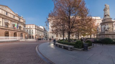 Panorama showing theater La Scala timelapse and a small park opposite to historic building with a monument to Leonardo da Vinci and his students. People walking around and sitting on a bench