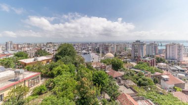 Panorama, Arnavutluk 'un Durres limanı ve şehir merkezinin (eski kent) hava manzarasını gösteriyor. Gökyüzünde bulutlar olan, kırmızı çatıları ve yeşil ağaçları olan birçok ev.