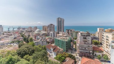 Panorama, Arnavutluk 'un Durres limanı ve şehir merkezinin (eski kent) hava manzarasını gösteriyor. Gökyüzünde bulutlar olan yeşil ağaçlı birçok ev