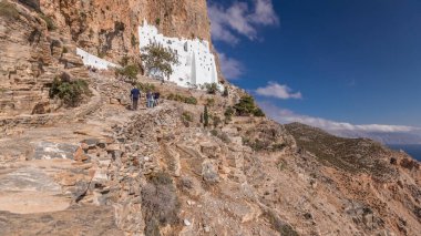 Panorama showing the famous white Hozoviotissa Monastery standing on a rock over the Aegean sea in Amorgos island timelapse hyperlapse, Cyclades, Greece.