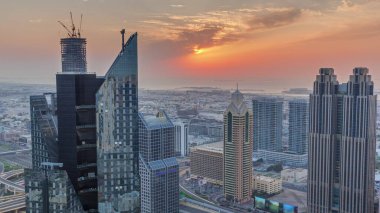 Dubai 'deki Sheikh Zayed Yolu' ndaki yüksek binalar. Gün batımında uluslararası finans bölgesinde gökdelenler. Arka planda evler ve villalar var.