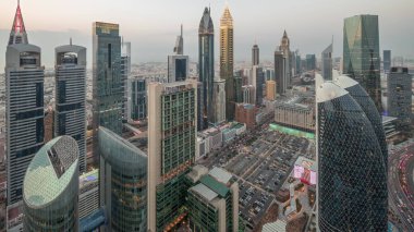 Dubai 'deki Sheikh Zayed Yolu' ndaki gökdelenlerin ufuk çizgisi manzarası. Günbegün hava geçiş zamanı, BAE. Aydınlatılmış gökdelenler ve yukarıdan Uluslararası Finans Merkezi 'ne park