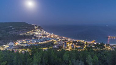 Atlantik Okyanusu 'nun ortasındaki Susimbra Köyü' nün kıyı şeridinden geceye hava görüntüsü. Kale 'nin bakış açısından aydınlatılmış evlerin olduğu akşam manzarası. Portekiz