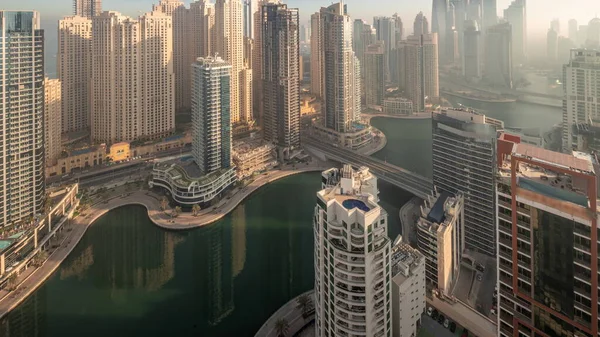 迪拜滨海区和Jbr区最高住宅区的各种摩天大楼的景观 经过人工运河的昼夜过渡时间 日出时的许多塔楼和游艇 — 图库照片