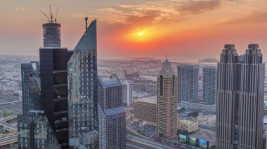 Dubai 'deki Sheikh Zayed Yolu' ndaki yüksek binalar. Gün batımında uluslararası finans bölgesinde gökdelenler. Arka planda evler ve villalar var.