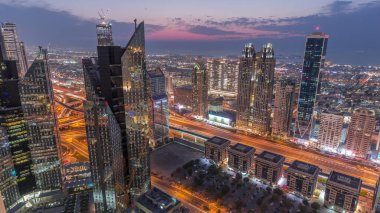 Dubai 'deki Sheikh Zayed Yolu' ndaki yüksek binalar. Gündüzden geceye geçiş zamanı, BAE. Uluslararası finans bölgesindeki gökdelenler. Şehir yürüyüş evleri ve arka planda trafik