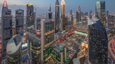 Dubai 'deki Sheikh Zayed Yolu' ndaki gökdelenlerin ufuk çizgisi manzarası. Günbegün hava geçiş zamanı, BAE. Aydınlatılmış gökdelenler ve yukarıdan Uluslararası Finans Merkezi 'ne park