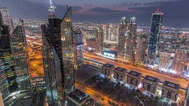 Dubai 'deki Sheikh Zayed Yolu' ndaki yüksek binalar. Gündüzden geceye geçiş zamanı, BAE. Uluslararası finans bölgesindeki gökdelenler. Şehir yürüyüş evleri ve arka planda trafik