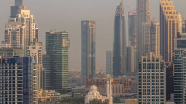 Dubai Business Bay hava sahasının gökdelenleriyle dolu şehir manzarası. Gündoğumunda mesken ve ofis kuleleriyle çevrili modern gökyüzü. Sıcak ışık ve uzun gölgeler