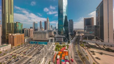 Güneş doğduktan sonra Dubai Uluslararası Finans Bölgesi. İş dünyasının panoramik manzarası ve uzun gölgeli finans kuleleri. Şehir merkezine yakın park yeri ve alışveriş merkezi olan gökdelenler.