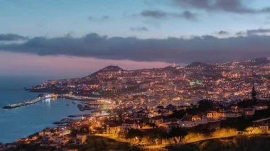 Gün batımından sonra adanın manzarası Funchal 'a gündüz, gece geçişi, Madeira, Portekiz zaman çizelgesi. Limanda akşam aydınlatması ve şehir ışıklarıyla