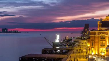 Waterfront view with the Padrao dos Descobrimentos Monument to the Discoveries day to night transition timelapse. Famous monument on the banks of the River Tagus in Lisbon with colorful clouds