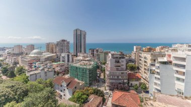 Panorama, Arnavutluk 'un Durres limanı ve şehir merkezinin (eski kent) hava manzarasını gösteriyor. Gökyüzünde bulutlar olan yeşil ağaçlı birçok ev