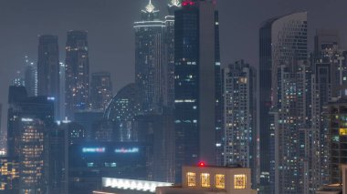 Dubai gökdelenleri aydınlatma ve pencereleri aydınlatma ile iş sahasında gece zaman dilimi. Birleşik Arap Emirlikleri 'nin şehir merkezinden hava görüntüsü.