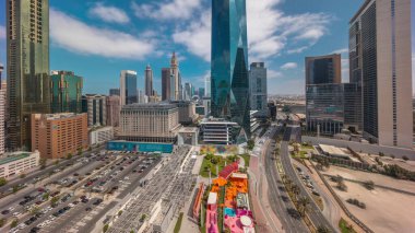 Güneş doğduktan sonra Dubai Uluslararası Finans Bölgesi. İş dünyasının panoramik manzarası ve uzun gölgeli finans kuleleri. Şehir merkezine yakın park yeri ve alışveriş merkezi olan gökdelenler.