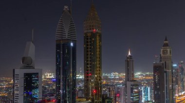 Dubai 'deki Sheikh Zayed Yolu' ndaki gökdelenlerin gökyüzü manzarası tüm gece sürüyor. Uluslararası Finans Merkezi 'nde yukarıdan aydınlatılmış gökdelenler ve ışıklar sönüyor
