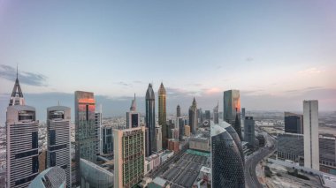 Dubai 'deki Sheikh Zayed Yolu' ndaki gökdelenlerin gökyüzü panoramik görüntüsü gece gündüz geçiş zamanı, BAE. Güneş doğmadan önce Uluslararası Finans Merkezi 'ndeki gökdelenler