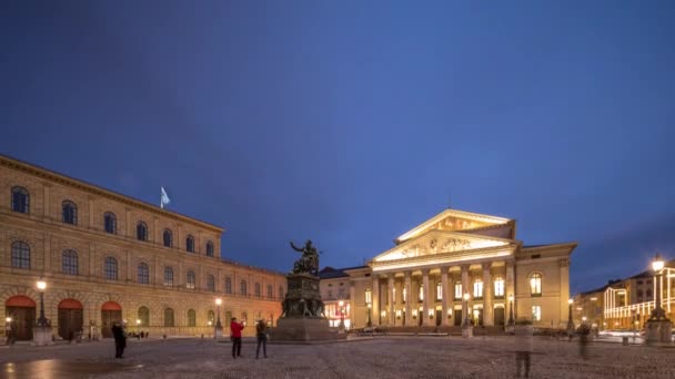 慕尼黑国家剧院或国家剧院位于马科斯 约瑟夫广场上 日以继夜地经过过渡时期 历史上的歌剧院巴伐利亚州立歌剧院的所在地中间的雕像 — 图库视频影像
