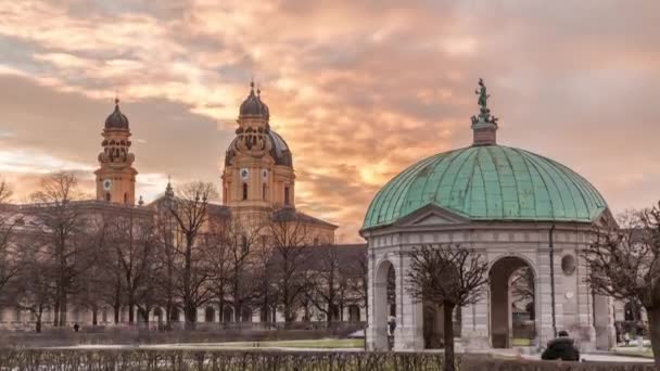 在日落时分 位于慕尼黑宫廷花园中心的黛安娜亭亭和巴伐利亚雕像在日落时分穿行 巴洛克教堂的背景是Theatinerkirche — 图库视频影像