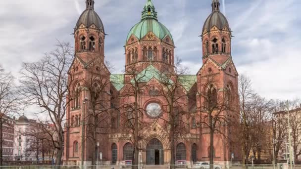 セントルーカス教会またはルーカシュ教会は ドイツ南部ミュンヘン最大のプロテスタント教会です 曇った空と路上の交通 — ストック動画