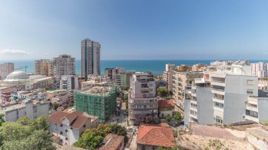Panorama, Arnavutluk 'un Durres limanı ve şehir merkezinin (eski kent) hava manzarasını gösteriyor. Gökyüzünde bulutlar olan yeşil ağaçlı birçok ev
