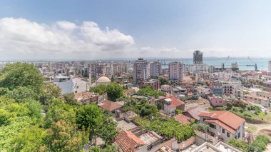 Panorama, Arnavutluk 'un Durres limanı ve şehir merkezinin (eski kent) hava manzarasını gösteriyor. Gökyüzünde bulutlar olan, kırmızı çatıları ve yeşil ağaçları olan birçok ev.