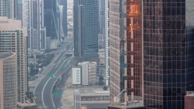 Hava görüntüsü Dubai 'deki yoğun kavşaklara gece gündüz geçiş zamanı. Gün doğmadan önce otoyolun her iki tarafına doğru giden arabalar var. İş bölgesi gökdelenleri