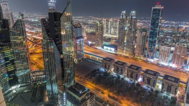 Dubai 'deki Sheikh Zayed Yolu' ndaki yüksek binalar. Gündüzden geceye geçiş zamanı, BAE. Uluslararası finans bölgesindeki gökdelenler. Şehir yürüyüş evleri ve arka planda trafik