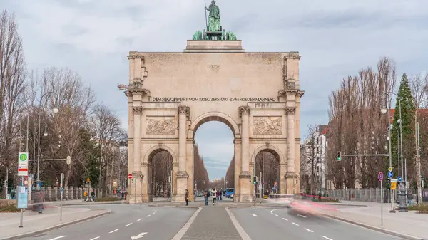 慕尼黑的西格斯特 Siegestor 或胜利门 Victory Gate 是一座纪念拱门 顶部是一座带有狮子四边形的巴伐利亚雕像 纪念碑周围街上的交通情况 后视镜德国 — 图库照片
