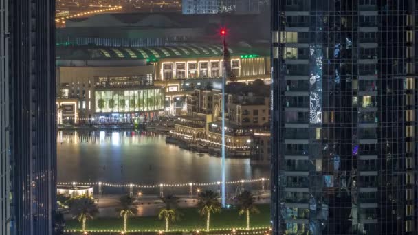 阿联酋城市市区迪拜喷泉的空中景观 在购物中心旁边停放着棕榈和国旗 整晚都在向南飞去 从上面看到两栋摩天大楼之间 灯都关掉了 — 图库视频影像