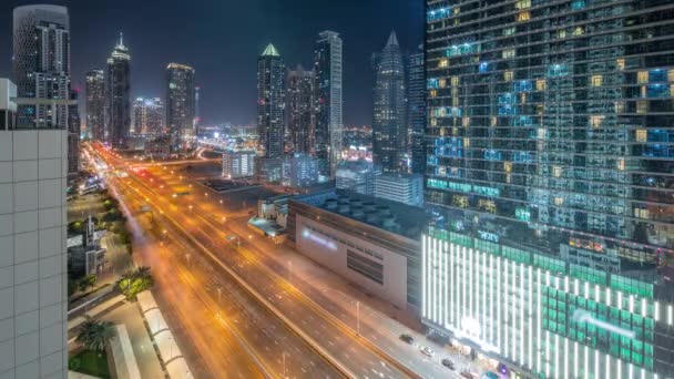 商业区的天际线与现代建筑的全景时间从上方通宵掠过 迪拜主要公路附近的摩天大楼和照明塔的空中景观 十字路口的交通 — 图库视频影像